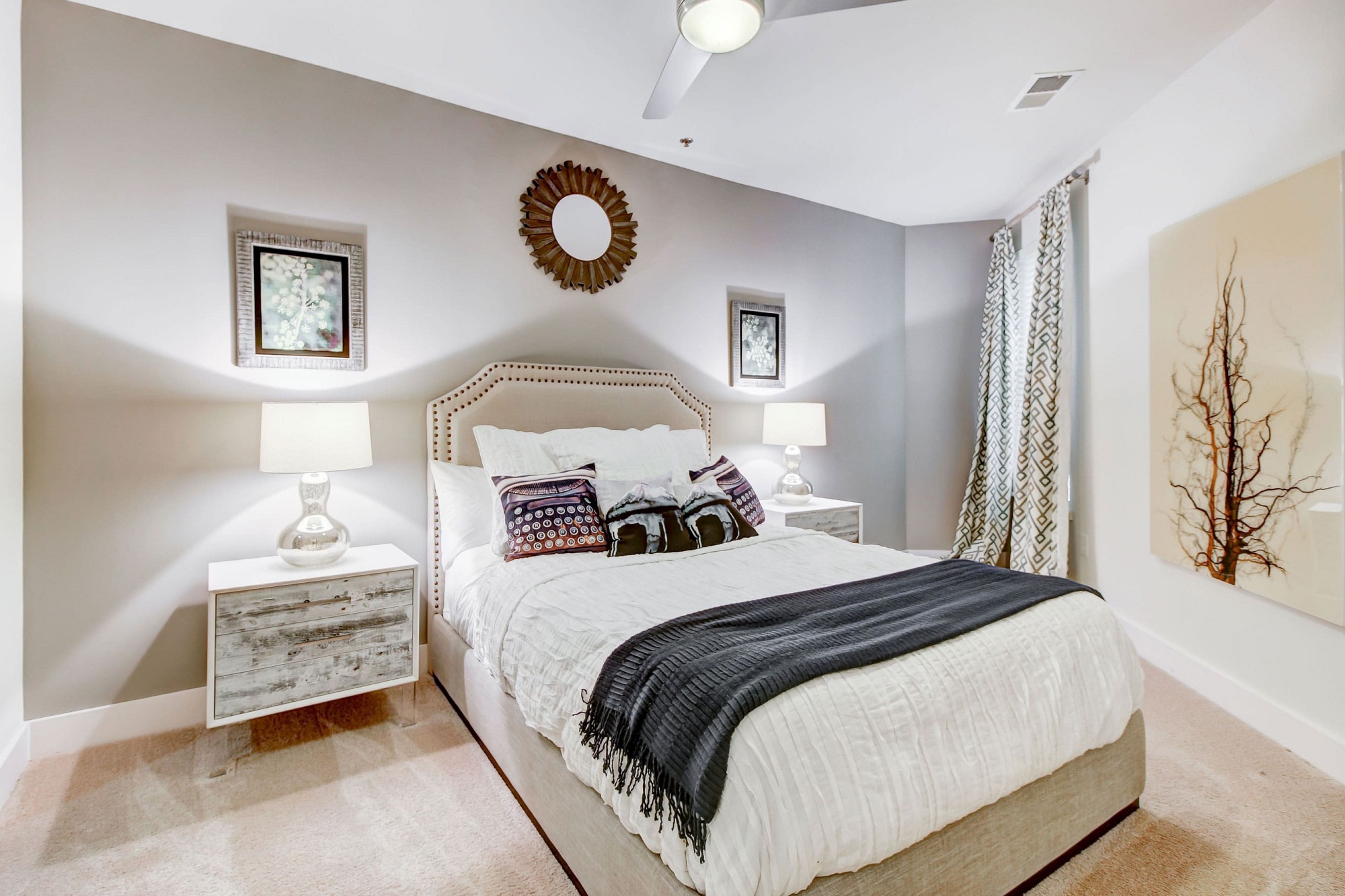 Furnished apartment bedroom with carpet flooring, a ceiling fan with light, and a window